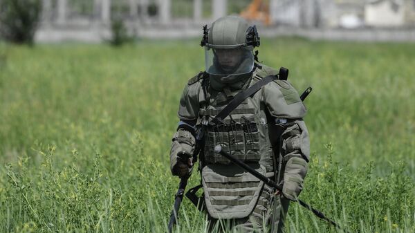 Сапер Международного противоминного центра Вооруженных сил РФ ищет мины и снаряды на бывших позициях ВСУ в Мариуполе