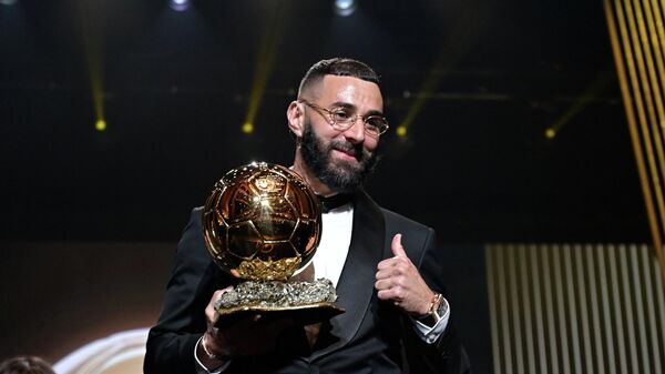 Нападающий мадридского Реала и сборной Франции по футболу Карим Бензема с наградой Золотой мяч