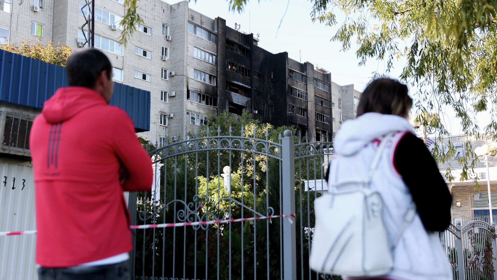 Люди у многоэтажного дома, повреждённого в результате крушения сверхзвукового истребителя-бомбардировщика Су-34 в Ейске - РИА Новости, 1920, 18.10.2022