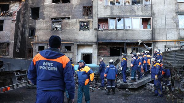 Сотрудники МЧС РФ у многоэтажного дома, повреждённого в результате крушения сверхзвукового истребителя-бомбардировщика Су-34 в Ейске