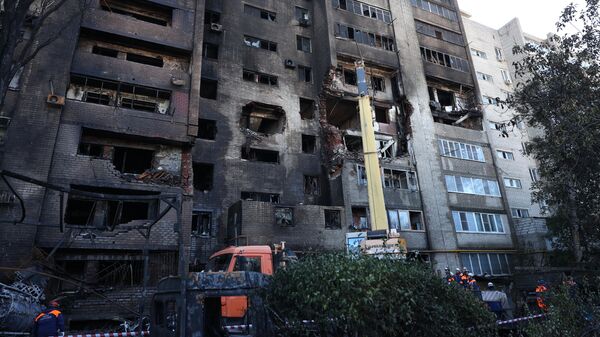 Сотрудники МЧС РФ у многоэтажного дома, повреждённого в результате крушения истребителя-бомбардировщика Су-34 в Ейске