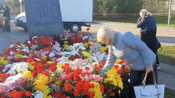 Жители Ейска несут цветы к стихийному мемориалу в память о погибших при крушении Су-34