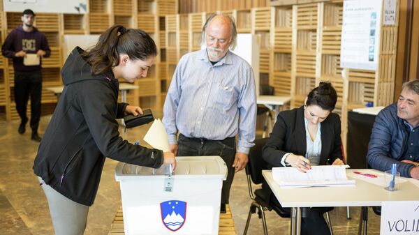 Женщина голосует на избирательном участке во время всеобщих выборов в Любляне, Словения