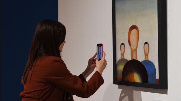 Посетительница фотографирует картину Анны Лепорской Три фигуры 