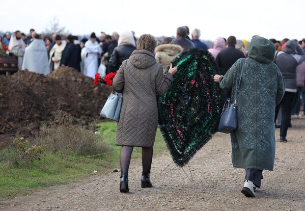 Горожане несут траурный венок во время похорон погибших при крушении самолета на новом кладбище города Ейск