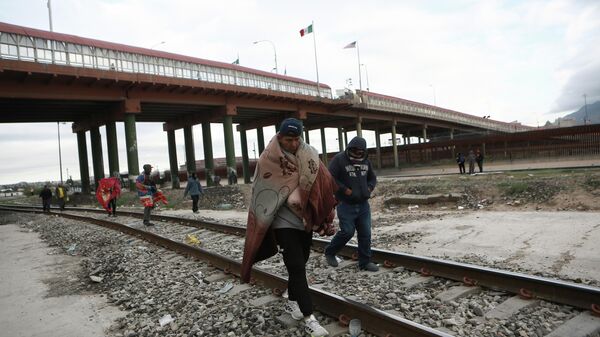 Мигранты около моста через реку Рио-Гранде на границе США и Мексики 