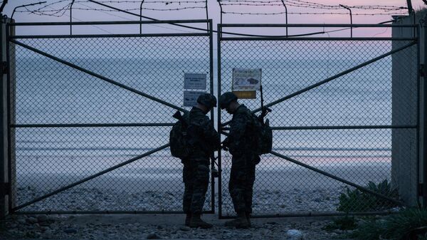 Южнокорейские военные у входа пляж на острове Ёнпхёндо недалеко от морской границы с Северной Кореей