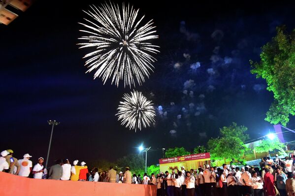 Люди смотрят фейерверк на берегу реки Сарайю накануне фестиваля Дивали