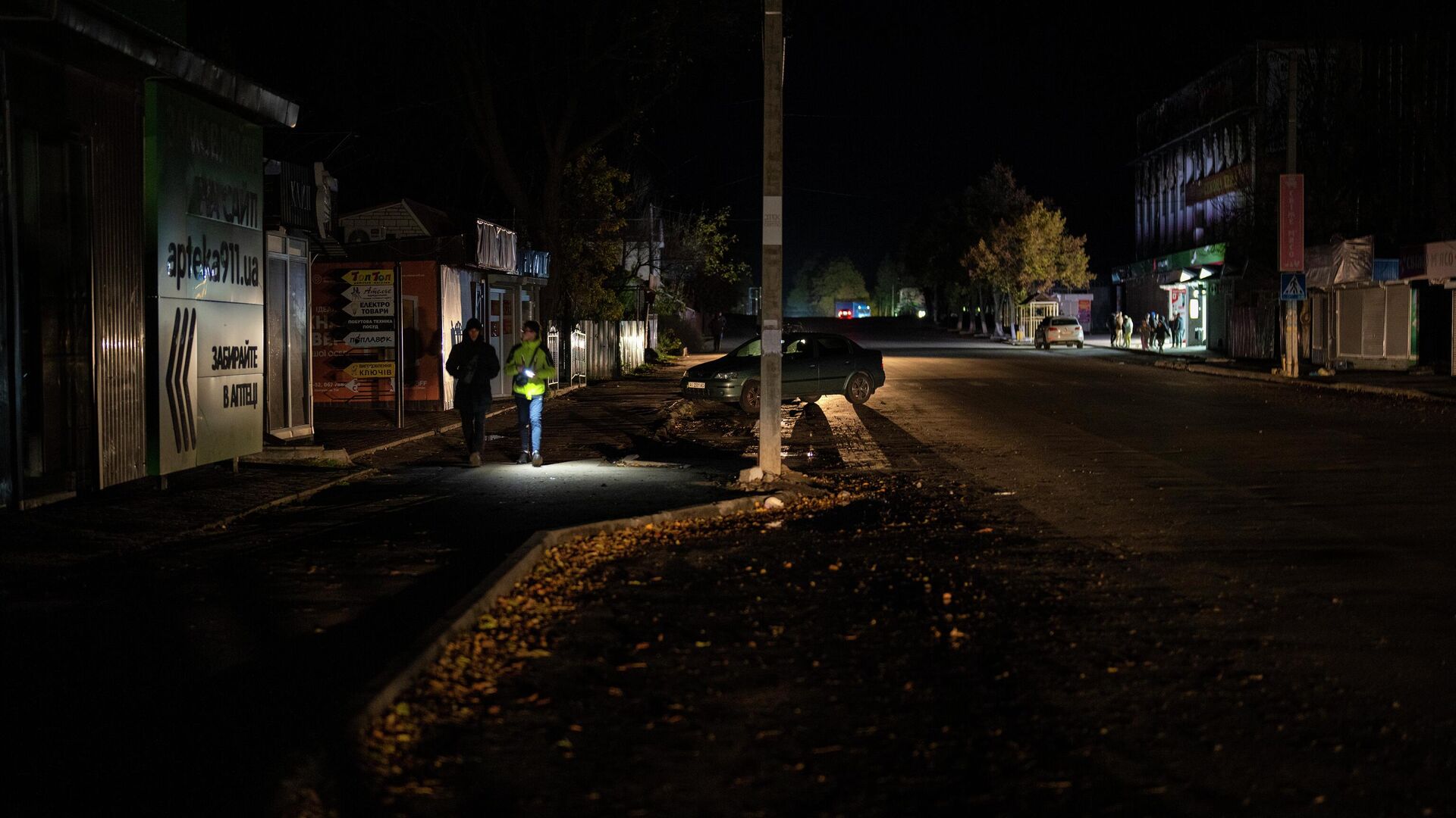 Люди идут по улице во время отключения электроэнергии в Бородянке в Киевской области - РИА Новости, 1920, 26.10.2022