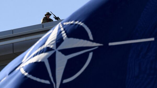 Сотрудник службы безопасности на крыше здания штаб-квартиры НАТО в Брюсселе