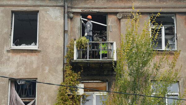 Рабочие во время работ по восстановлению жилого дома на одной из улиц в Мариуполе