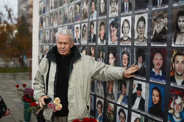 Мужчина у мемориальной доски с фотографиями жертв захвата террористами мирных людей на мюзикле Норд-Ост в Театральном центре на Дубровке, во время мероприятия, посвященного 20-й годовщине со дня трагических событий