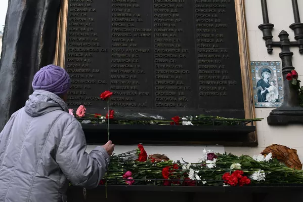 Женщина возлагает цветы к мемориальной доске с именами жертв захвата террористами мирных людей на мюзикле Норд-Ост в Театральном центре на Дубровке, во время мероприятия, посвященного 20-й годовщине со дня трагических событий