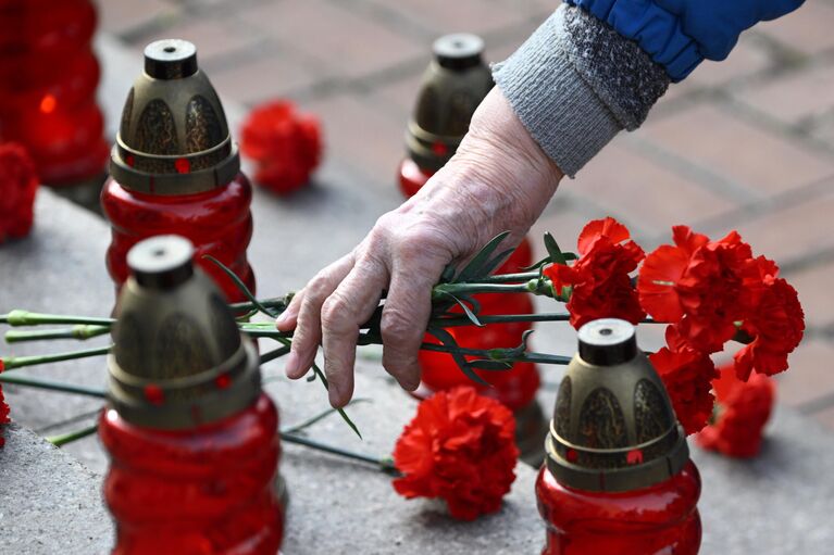 Пожилая женщина возлагает цветы на мероприятии, посвященном 20-й годовщине со дня трагических событий захвата террористами мирных людей на мюзикле Норд-Ост в Театральном центре на Дубровке