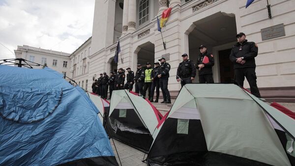 Сотрудники полиции Молдавии и палатки участников акции протеста у Генеральной прокуратуры Кишинева