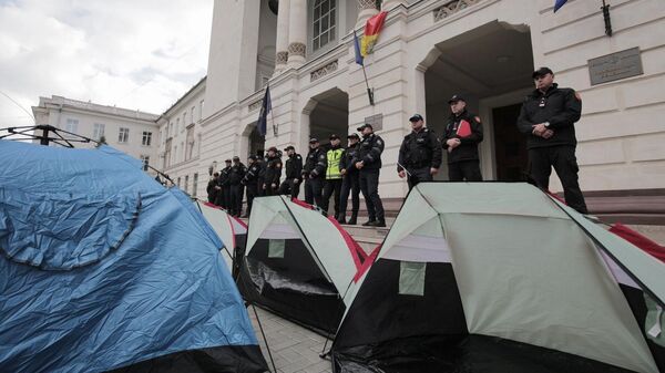 Сотрудники полиции Молдавии и палатки участников акции протеста у Генеральной прокуратуры Кишинева
