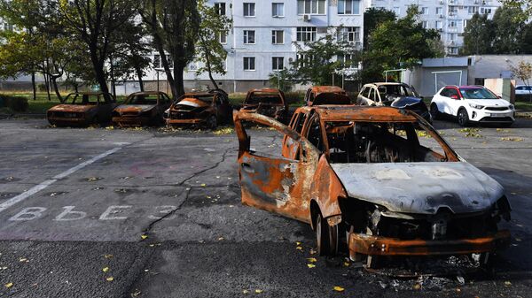 Уничтоженные автомобили у жилых домов, пострадавших в результате обстрелов, в Энергодаре
