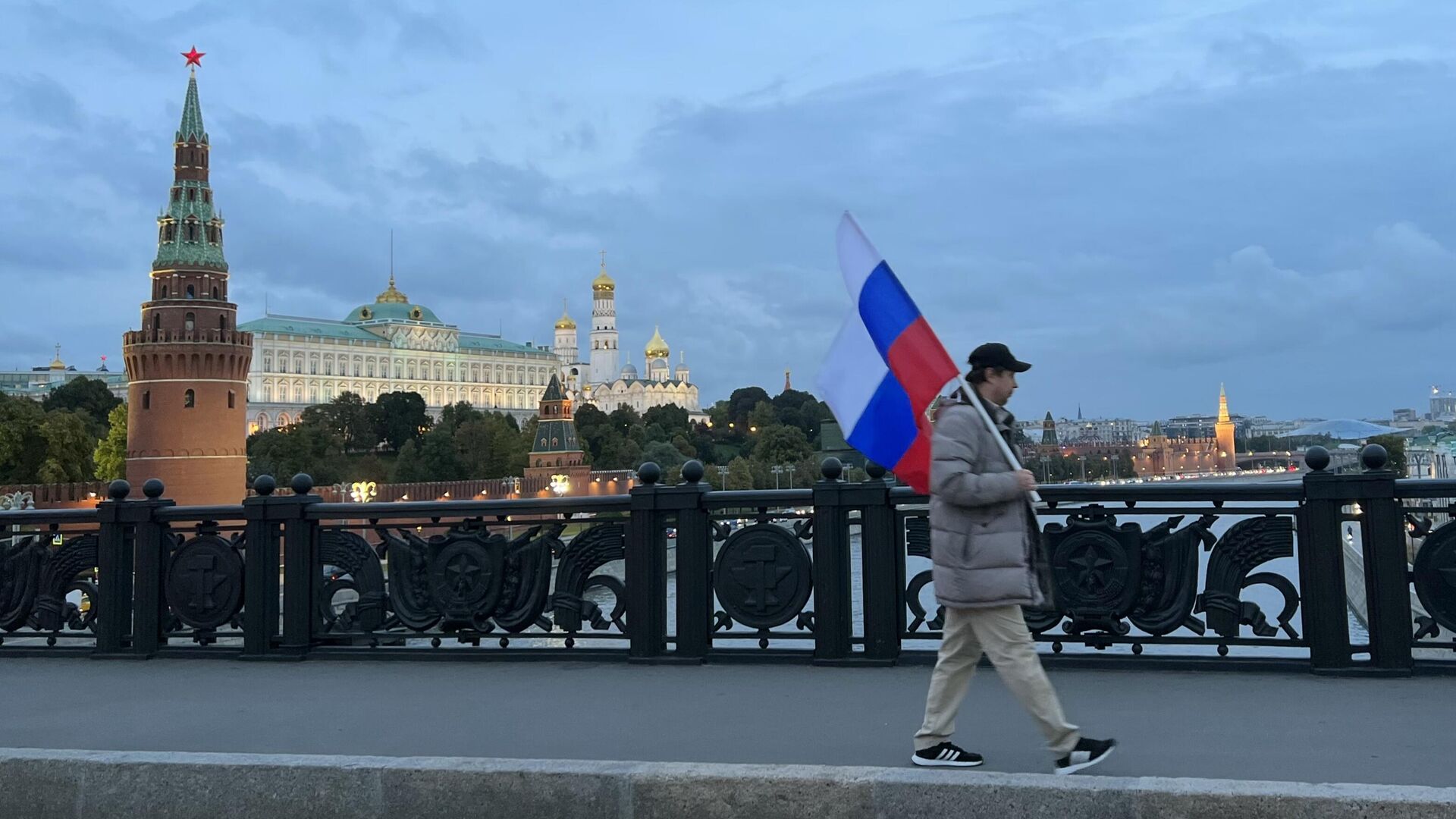 Мужчина с флагом России идет по Большому Каменному мосту в Москве - РИА Новости, 1920, 19.02.2024