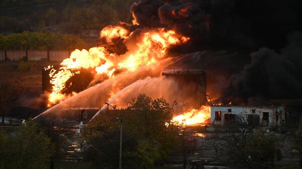 Пожарные во время тушения пожара, возникшего в результате повторного обстрела ВСУ, на территории нефтебазы в Шахтерске