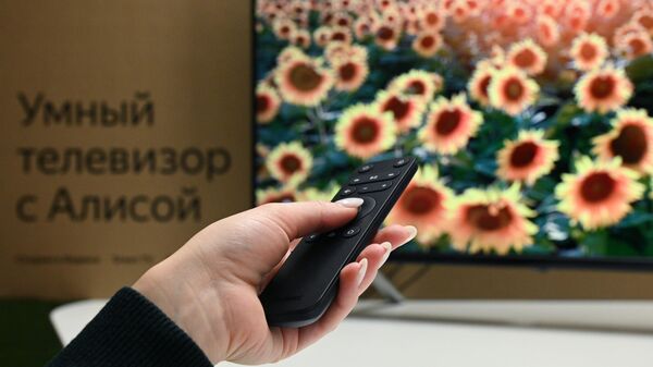 Сотрудница компании Яндекс демонстрирует первый умный телевизор с голосовым помощником Алисой 