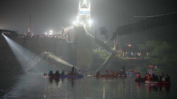 Спасатели рядом с обрушившимся вантовым подвесным мостом в городе Морби в западном штате Гуджарат, Индия