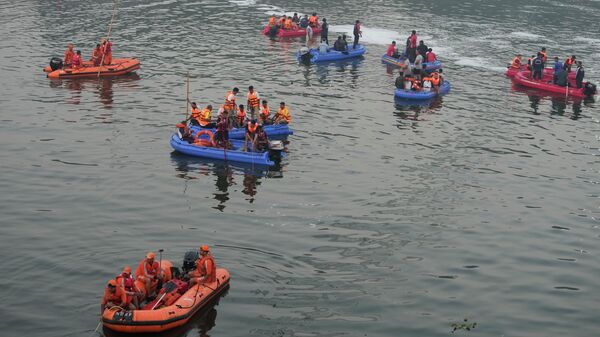 Спасатели рядом с обрушившимся вантовым подвесным мостом в городе Морби в западном штате Гуджарат, Индия