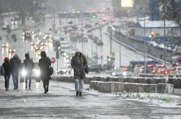 Прохожие во время снегопада на Ленинском проспекте в Москве