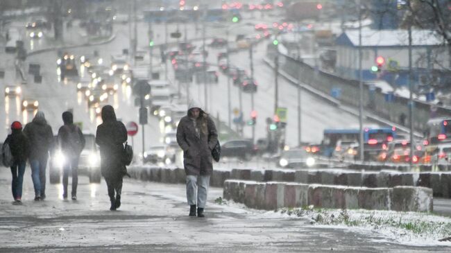 Прохожие во время снегопада на Ленинском проспекте в Москве