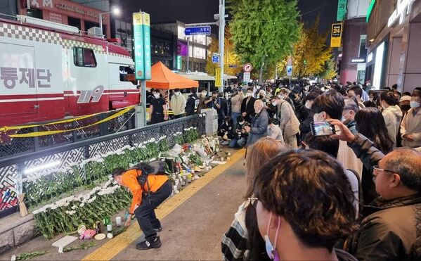 Люди возлагают цветы рядом с местом трагедии, в результате которой погибли 151 человек в Сеуле