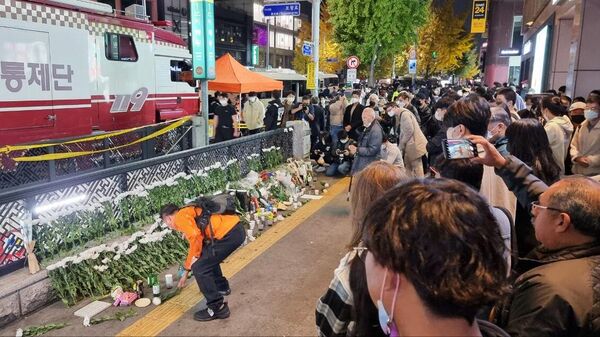 Люди возлагают цветы рядом с местом трагедии, в результате которой погибли 151 человек в Сеуле