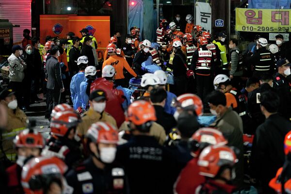 Спасатели пытаются вынести пострадавших с места трагедии в Сеуле, Южная Корея.