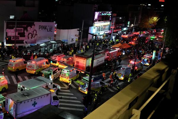 Машины скорой помощи и спасатели прибывают на улицу возле места давки в Сеуле, Южная Корея