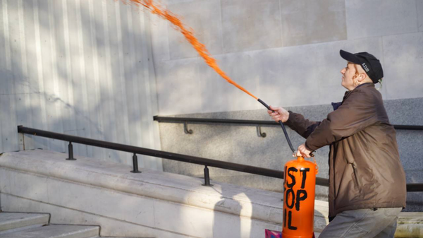 Активисты экологического движения Just Stop Oil распыляют оранжевую краску на здания