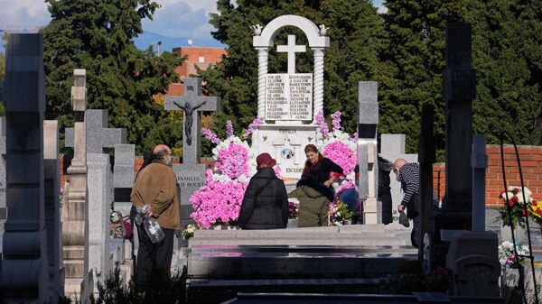 Люди посещают могилы близких на кладбище во время Дня всех святых в Мадриде