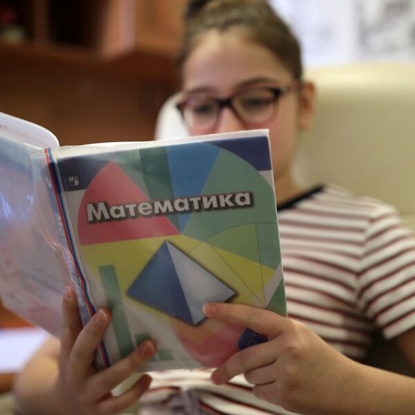 Школьница учит таблицу умножения по учебнику Школьница учит таблицу умножения по учебнику
