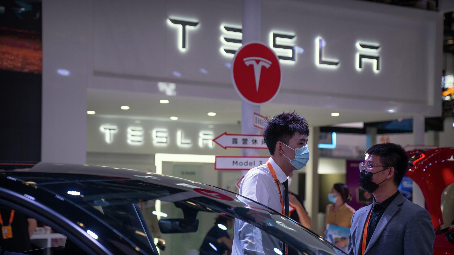 Сотрудники разговаривают возле автомобилей на выставке автопроизводителя Tesla на Китайской импортной ЭКСПО - РИА Новости, 1920, 07.04.2023