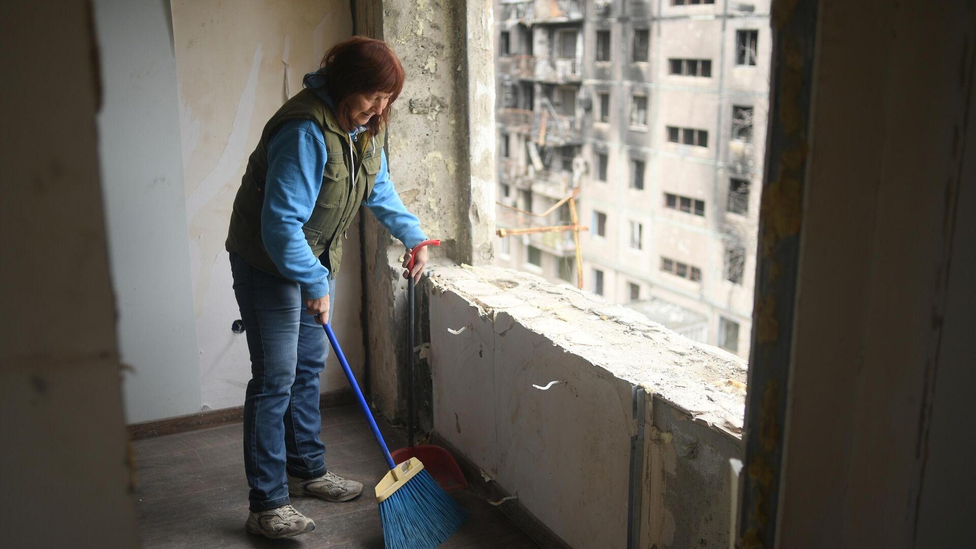 Жительница Мариуполя убирает мусор в квартире одного из разрушенных домов - РИА Новости, 1920, 21.12.2022