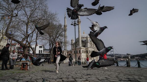 Туристы на набережной недалеко от мечети Ортакёй в Стамбуле