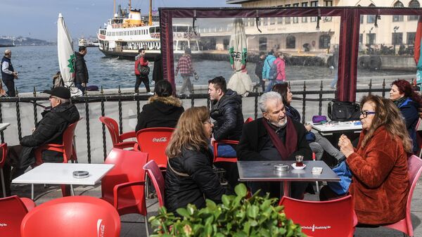Люди отдыхают в кафе в районе Кадыкей города Стамбул