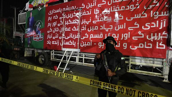Офицер полиции перед грузовиком бывшего премьер-министра Пакистана Имран Хан, оцепленым после перестрелки в Вазирабаде