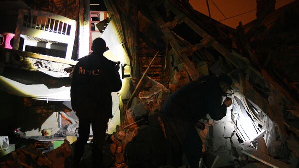 Сотрудники МЧС осматривают жилой дом, частично разрушенный в результате обстрела ВСУ Донецка