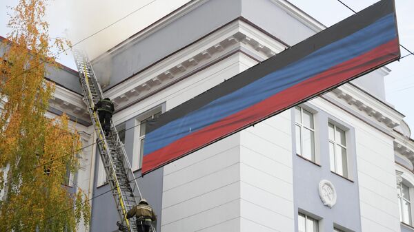 Сотрудники пожарно-спасательного центра работают на месте пожара в здании управления железными дорогами в Донецке, возникшего в результате обстрела ВСУ