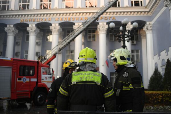 Сотрудники пожарно-спасательного центра работают на месте пожара в здании управления железными дорогами в Донецке, возникшего в результате обстрела ВСУ