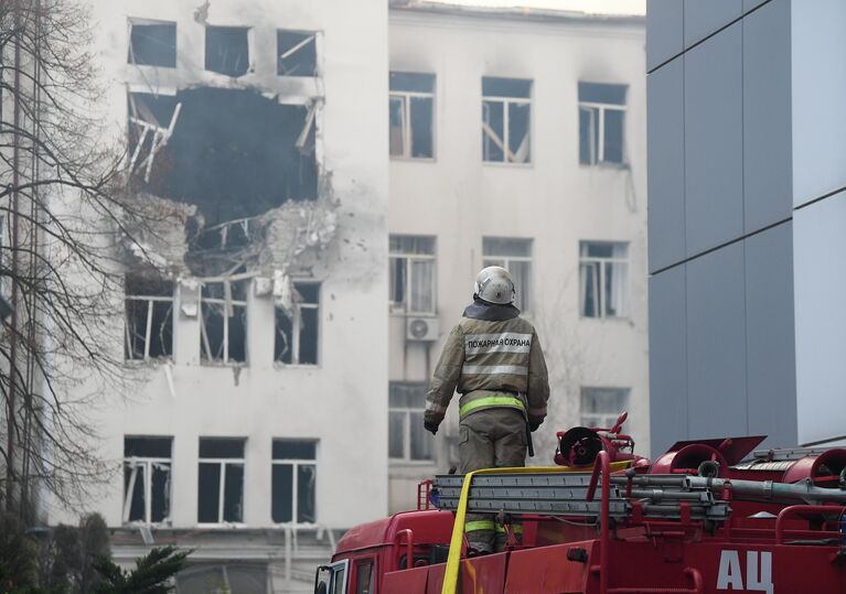 Сотрудник пожарно-спасательного центра у дома, пострадавшего в результате обстрела ВСУ в Донецке