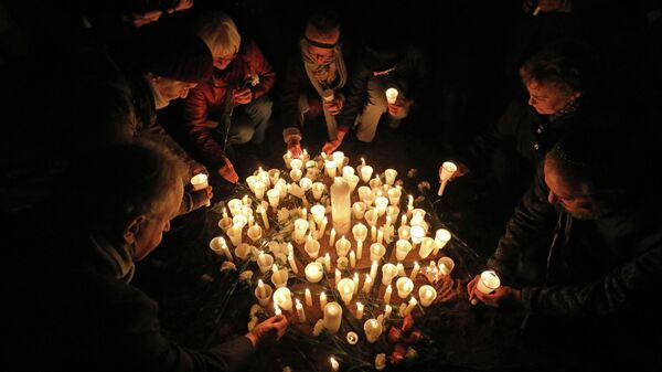 Люди зажигают свечи на месте бывшей синагоги в Шверине, поскольку Германия в память о Хрустальной ночи.