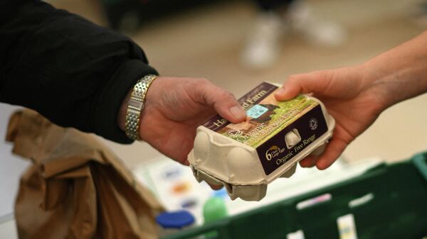 Коробка яиц в руках сотрудника продовольственного склада в Лондоне