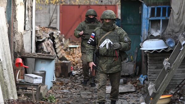 Сотрудники Следственного комитета РФ фиксируют последствия обстрелов во дворе жилого дома в Донецке