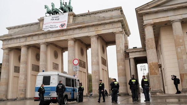 Экоактивисты движения Последнее поколение растянули плакат на Бранденбургских воротах в Германии