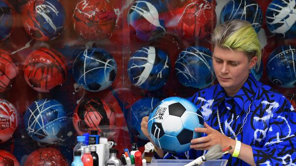 Художник-каллиграф Покрас Лампас создаёт арт-объект из 432 расписанных мячей на стенде ПАО Газпром 