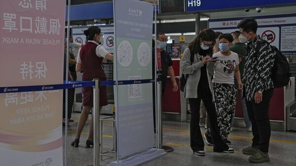 Туристы заполняют декларации о состоянии здоровья на стойке регистрации в международном аэропорту Пекин